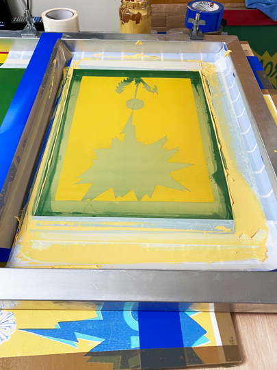 This is the silkscreen after pulling a colour across the mask. The colour area is where the paint has pushed through the silk. The other areas are the masks, where the paint is applied. That's the idea anyway!